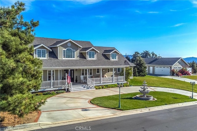 cape cod-style house with curved driveway, covered porch, and a front yard