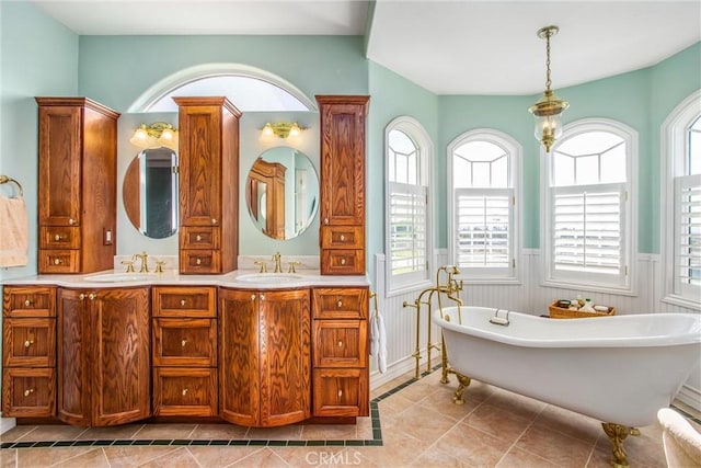 full bath with wainscoting, a sink, and a wealth of natural light