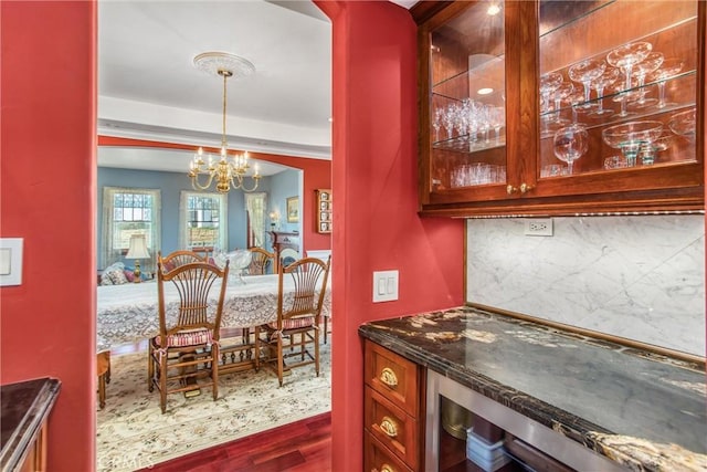interior space featuring an inviting chandelier, beverage cooler, and wood finished floors