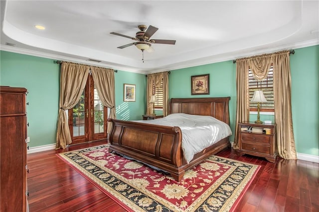 bedroom with a raised ceiling, baseboards, and hardwood / wood-style flooring