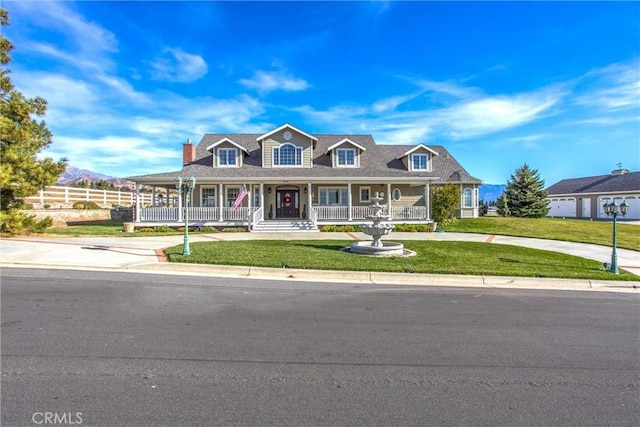 farmhouse with a porch, curved driveway, fence, and a front yard