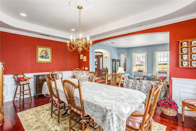dining area featuring arched walkways, visible vents, hardwood / wood-style flooring, and a raised ceiling