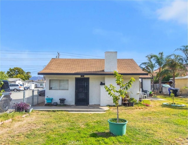 rear view of property featuring a lawn