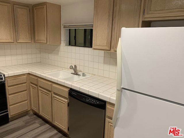 kitchen featuring dark wood-type flooring, dishwasher, white refrigerator, and tile countertops