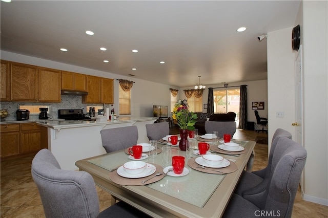 tiled dining room featuring a notable chandelier