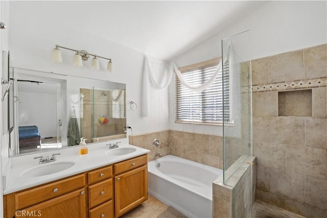 bathroom featuring separate shower and tub, vanity, vaulted ceiling, and tile patterned flooring