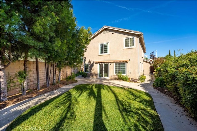 rear view of house featuring a lawn