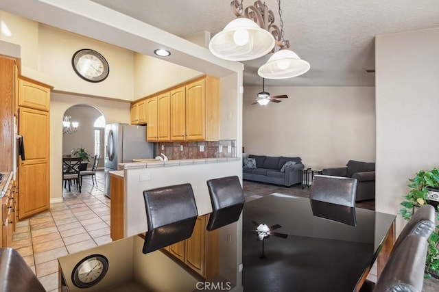 interior space with ceiling fan, a textured ceiling, and light tile patterned floors