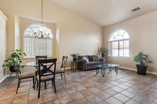 dining space featuring tile patterned flooring, a notable chandelier, and high vaulted ceiling