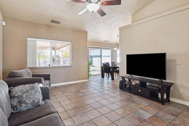 living room with ceiling fan and a textured ceiling