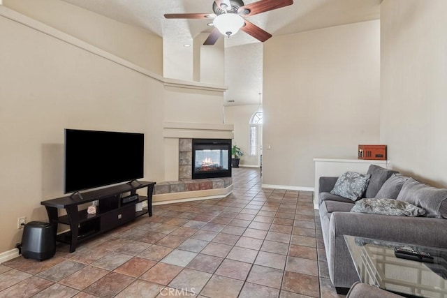 living room with a tiled fireplace, tile patterned floors, and ceiling fan