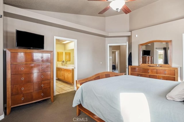 bedroom featuring vaulted ceiling, light colored carpet, ceiling fan, and ensuite bath