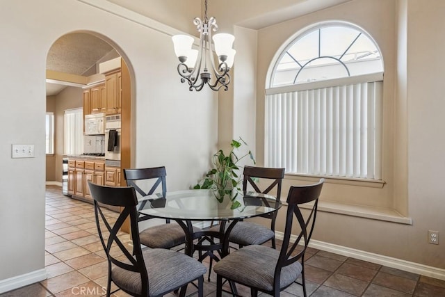 dining space featuring an inviting chandelier and tile patterned flooring