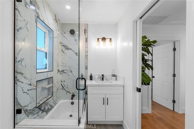 bathroom featuring combined bath / shower with glass door, vanity, and hardwood / wood-style flooring