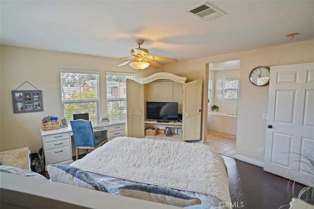 bedroom with ceiling fan, ensuite bath, wood-type flooring, and built in desk