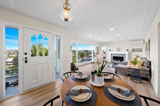 dining area featuring light hardwood / wood-style floors and a wall mounted air conditioner