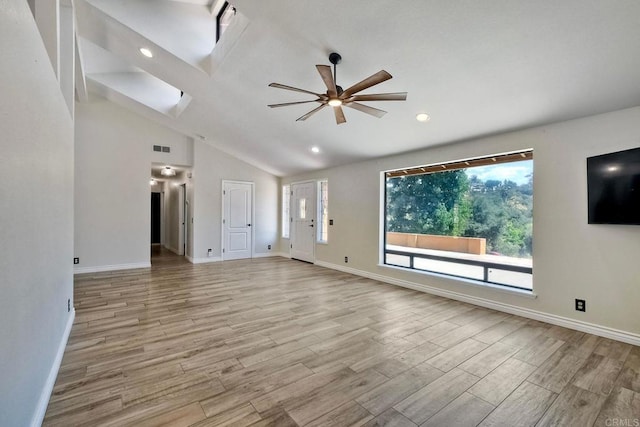 unfurnished living room featuring ceiling fan, vaulted ceiling, and light wood-type flooring