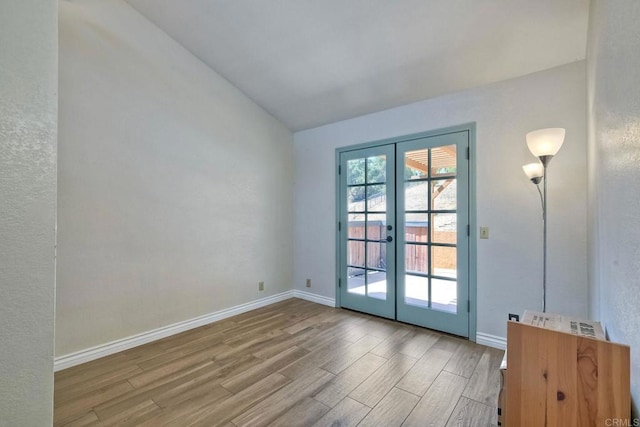 entryway featuring lofted ceiling, light hardwood / wood-style flooring, and french doors