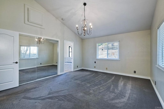 unfurnished room featuring dark colored carpet, high vaulted ceiling, and an inviting chandelier