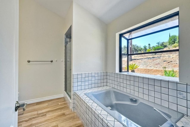 bathroom with wood-type flooring and independent shower and bath