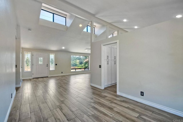 interior space with light hardwood / wood-style floors and high vaulted ceiling