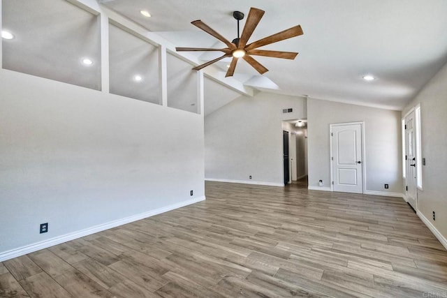 unfurnished living room with light wood-type flooring, ceiling fan, and vaulted ceiling with beams