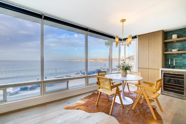 sunroom with a water view and beverage cooler