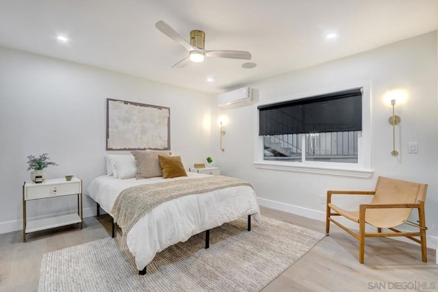 bedroom featuring ceiling fan, a wall mounted AC, and light wood-type flooring