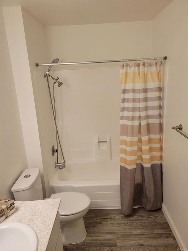 bathroom featuring toilet, wood finished floors, vanity, and shower / tub combo with curtain