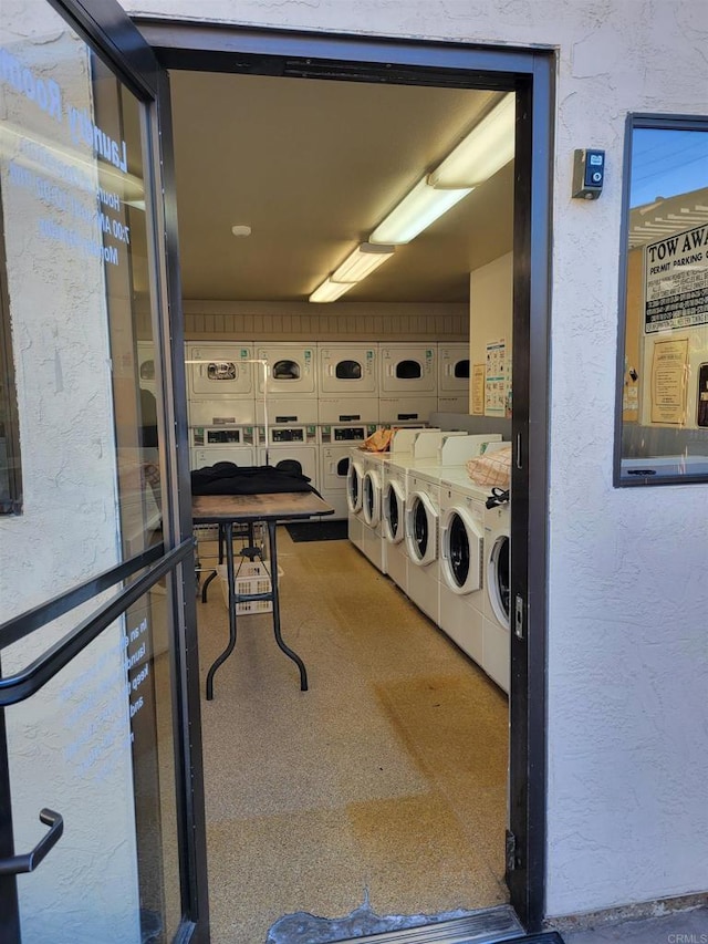 common laundry area featuring a textured wall and washer and dryer