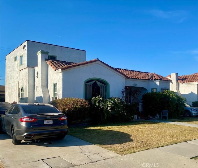 mediterranean / spanish home with a front lawn