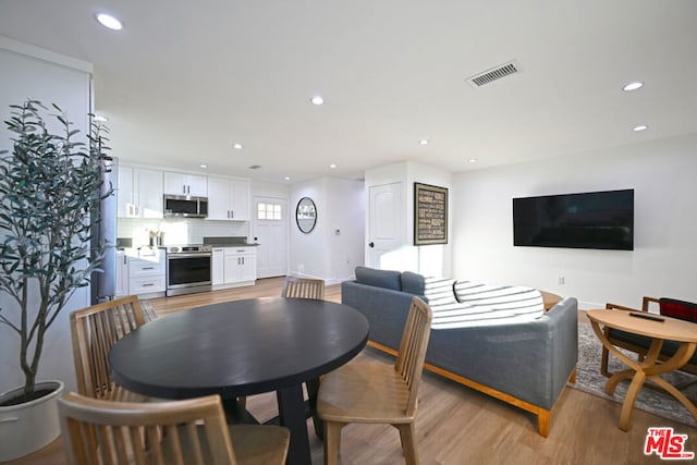 dining space with light hardwood / wood-style flooring