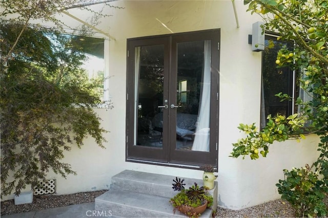 entrance to property featuring stucco siding and french doors