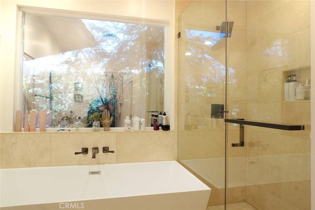 full bathroom with a soaking tub and a shower stall