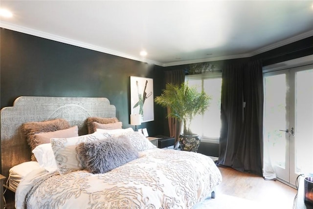 bedroom with french doors, crown molding, and wood finished floors