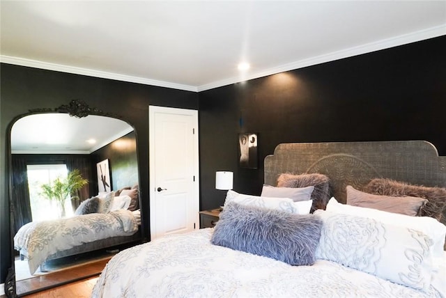 bedroom featuring arched walkways, crown molding, and wood finished floors