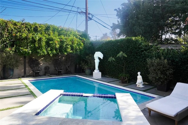 view of swimming pool featuring a patio area, a fenced backyard, and a pool with connected hot tub