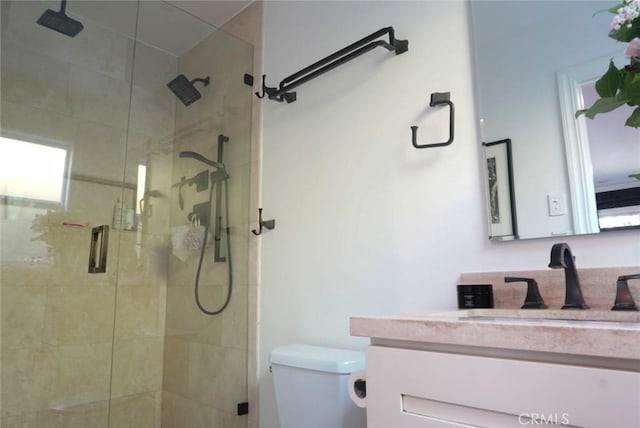 full bathroom featuring toilet, a shower stall, and vanity