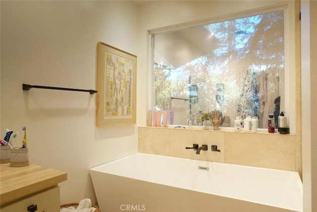 bathroom with a freestanding tub and vanity