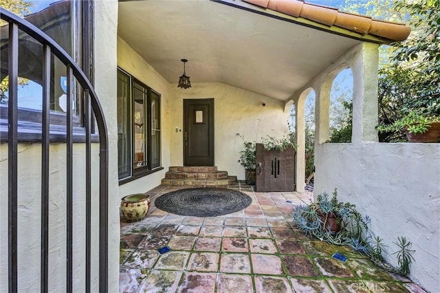 doorway to property with a patio area, fence, and stucco siding