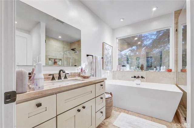 full bathroom featuring a stall shower, a freestanding tub, vanity, and recessed lighting