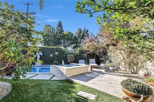 view of pool featuring a fenced backyard, an in ground hot tub, a lawn, a fenced in pool, and a patio area