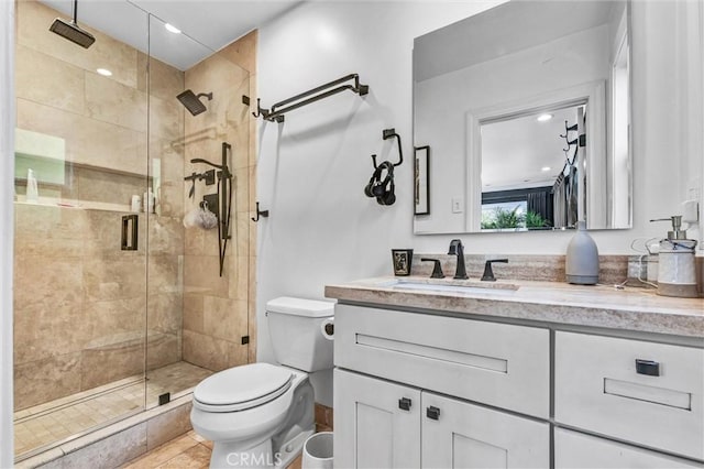 full bathroom featuring a stall shower, vanity, toilet, and recessed lighting