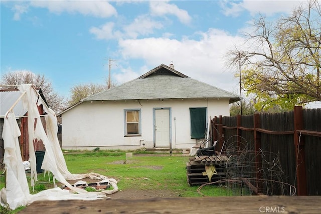 rear view of property featuring a lawn