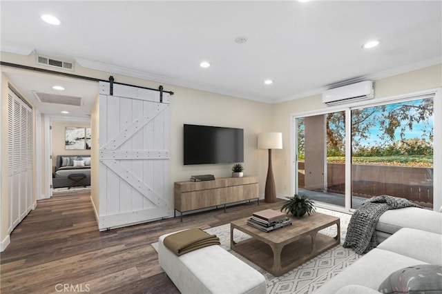 living room featuring ornamental molding, a wall mounted AC, a barn door, and wood-type flooring