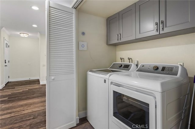 clothes washing area featuring cabinets, separate washer and dryer, crown molding, and dark wood-type flooring