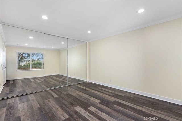 interior space featuring dark wood-type flooring, a closet, and ornamental molding