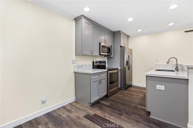 kitchen featuring dark wood-type flooring, stainless steel appliances, gray cabinetry, and sink