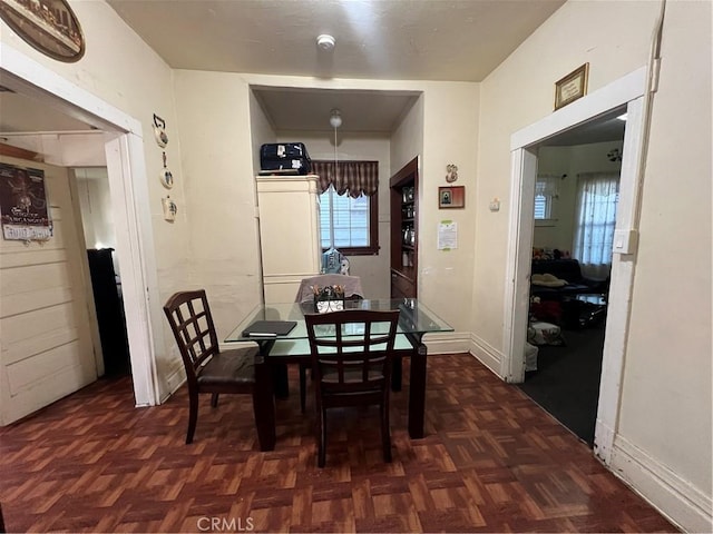 dining space with a notable chandelier and dark parquet flooring