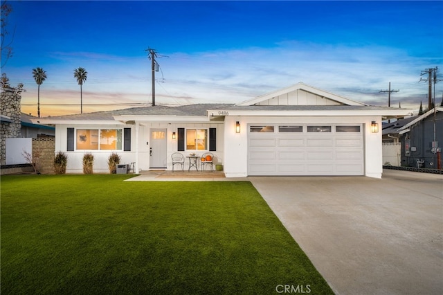 ranch-style house with a garage and a yard